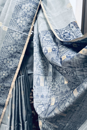 Grey color body with round Zari Butis, Navy Blue Ikkat border and Pallu with Gold Selvedge Soft Silk Saree