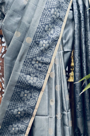 Grey color body with round Zari Butis, Navy Blue Ikkat border and Pallu with Gold Selvedge Soft Silk Saree