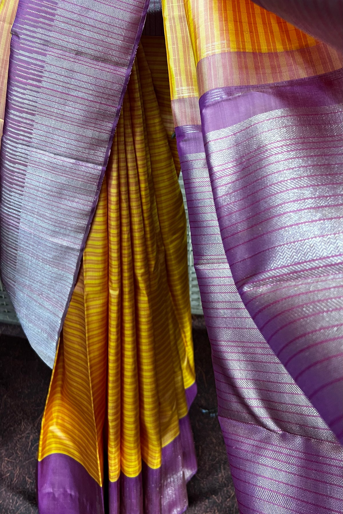 Mustard Kanchipuram saree with horizontal pattern beautifully complemented with stylist contemporary border.