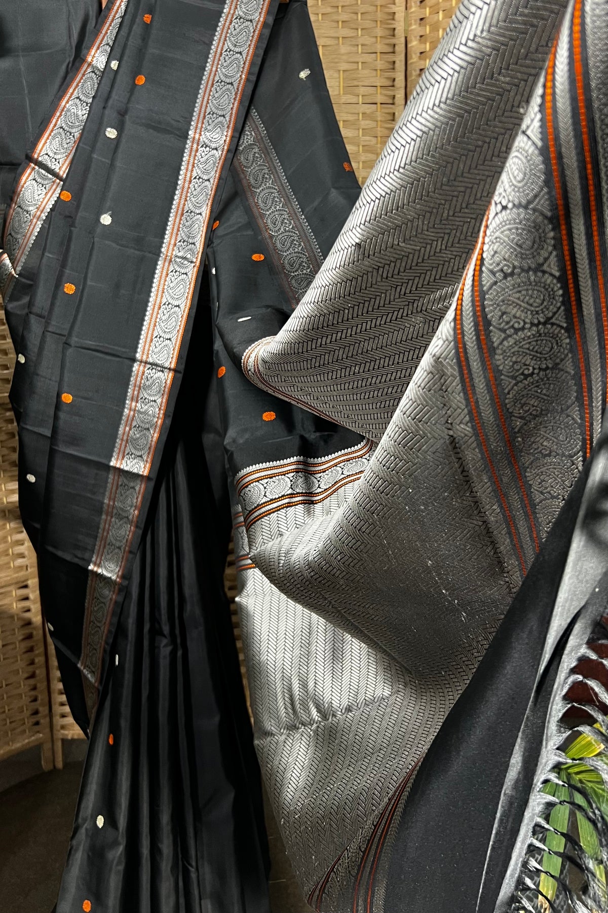 Black handwoven Kanchipuram Silk saree with burnt orange and silver mangaa motifs